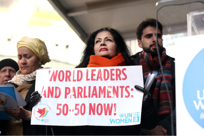 Woman holding sign demanding equality
